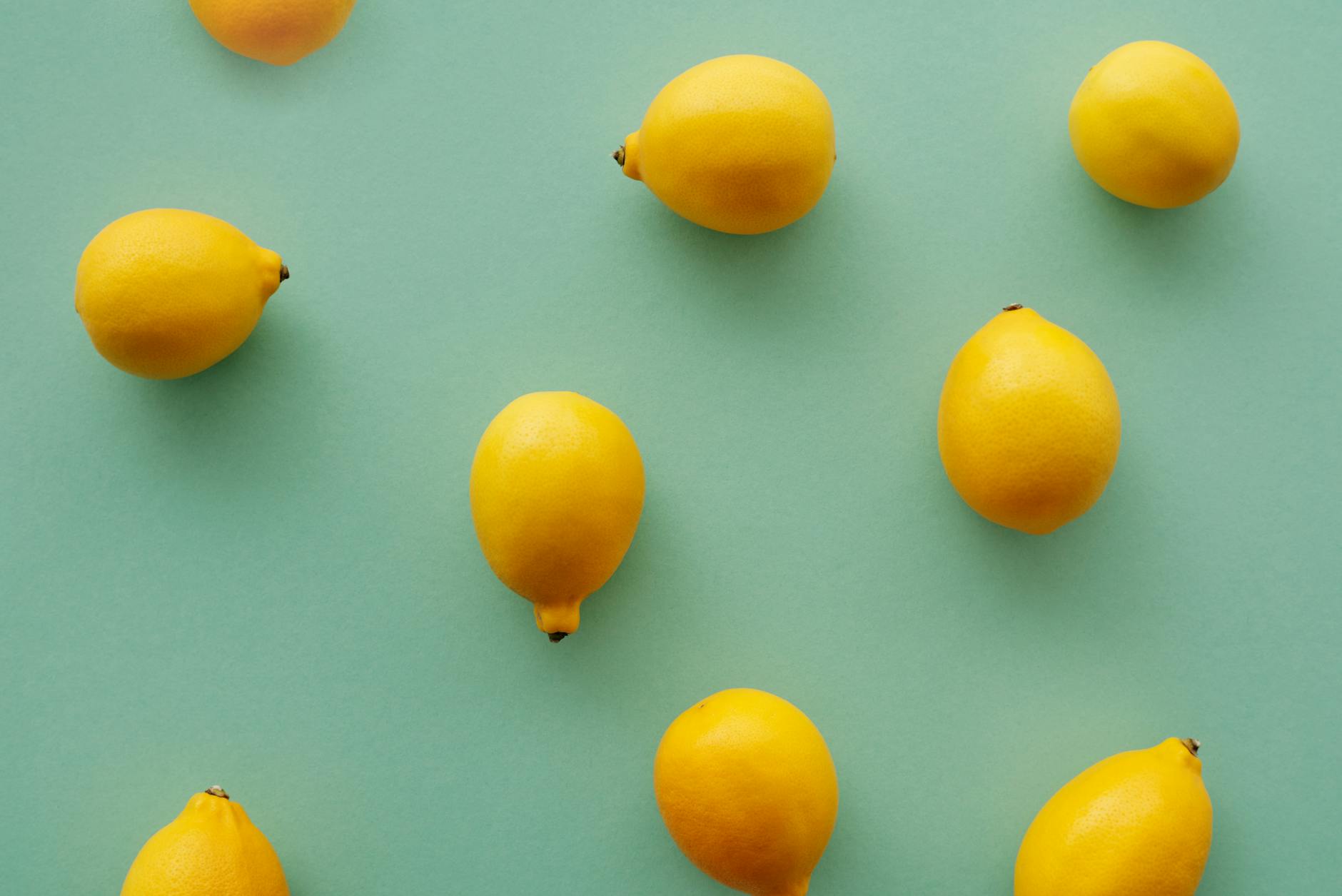 Bright yellow lemons arranged on a pastel green background symbolizing fresh approaches to changing bodies
